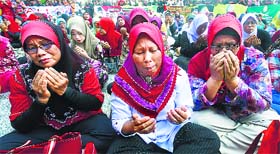 Muslim women recite a prayer outside the court in Putrajaya, outside Kuala Lumpur, on Monday.