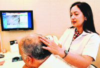 A hair specialist examines the hair strength before transplant at a centre in Sector 8, Chandigarh. Tribune photo: Parvesh Chauhan