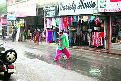 Tourists scamper for cover as rain lashes Mussoorie on Tuesday. a tribune photograph