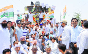 Congress workers block the passage of a train in protest against the railway fare hike in Sirsa on Tuesday.