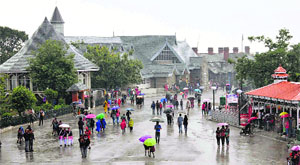 People walk with umbrellas during rain in Shimla on Tuesday.