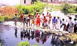 Environmentalist Balbir Singh Seechewal along with his followers makes a bundh at Kala Sanghian drain in Jalandhar on Tuesday.