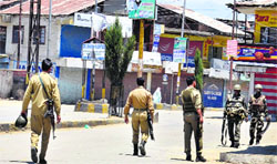 Security forces patrol a street in Sopore town during curfew on Tuesday. Tribune Photo: Amin War