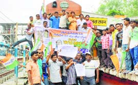 TMC activists stop a train in protest against hike in rail fares in Malda on Tuesday.