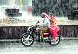 Commuters rush to escape the sudden rain near Fauji Chowk in Bathinda on Wednesday.