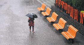 A commuter makes her way through a downpour in Shimla on Wednesday.