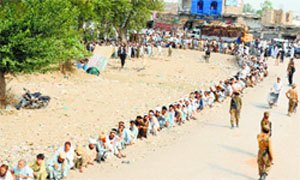 Internally displaced Pakistanis, fleeing a military operation in the North Waziristan tribal agency, wait in line outside a World Food Programme aid distribution centre in Bannu on Wednesday. AFP
