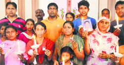 Family members of four Amritsar youths, who are lodged in an Iraqi jail for travelling without valid documents, hold their photographs in Amritsar on Thursday. Photo: Vishal Kumar