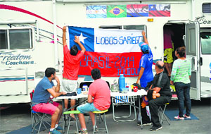 Chile fans fix their national flag on their mobile home at a new camping site in Rio de Janeiro.