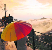 A tourist enjoys the hues of nature after Shimla received heavy rain on Friday.
