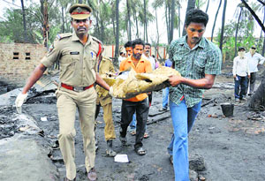 People carry the body of a victim near the blast site in Godavari district of Andhra Pradesh on Friday.