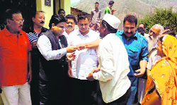 Rajesh Goyal, chief of RG Charitable Trust, gives away keys of houses built by the trust at Rudraprayag on Saturday. a tribune photograph