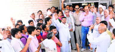 Farmers protest against land acquisition in the presence of district officials at the PWD rest house in Jhajjar on Friday.