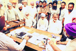 Farmers take up their problems with PSPCL officials. a tribune photograph