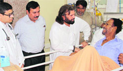 Hans Raj Hans enquires about the health of Barkat Sidhu at Dayanand Medical College and Hospital in Ludhiana on Saturday. Photo: Inderjeet verma