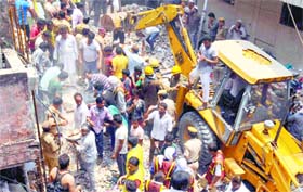 Delhi cave-in: Rescuers and local residents remove debris after a three-storey building collapsed at Inderlok in north Delhi on Saturday. Ten persons were killed and two injured in the cave-in