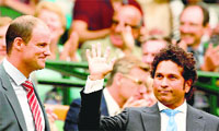 Sachin Tendulkar waves as Andrew Strauss looks on in the royal box before the start of the match between Rafael Nadal and Mikhail Kukushkin in London on Saturday. AFP