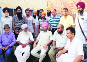 AAP leader Dr Daljit Singh (pink turban) at Varpal Kalan village with the family members of a youth stranded in Iraq