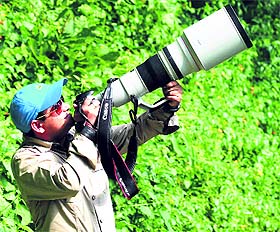 District Magistrate, Bareilly, Sanjay Kumar watches birds through a tellylens near Dehradun on Sunday.