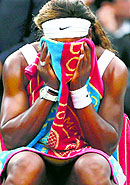 Serena Williams holds a towel to her face during a break