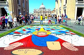 People visit the historic infiorata which shows multicoloured flower carpet featuring half a million flowers, two tonnes of salt and 100 bags of coloured sawdust to create a series of 50 images in Rome on Sunday. 