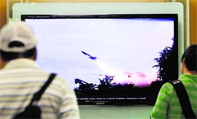 People watch TV showing the missile launch conducted by North Korea, in Seoul on Sunday. 