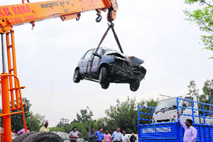 A crane lifts a car impounded by the MC staff during an anti-encroachment drive at the motor market in Sector 48-C, Chandigarh, on Monday.