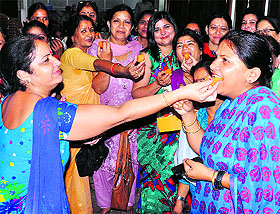 Members of BJP womens wing celebrate at the party office in Dehradun on Monday.
