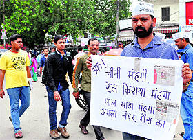 Aam Aadmi Party workers stage a silent protest against the price hike at Clock Tower 