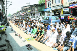 Muslims offer prayers on the main road at Budshah Chowk on the first day of the fasting month of Ramadan in Srinagar on Monday.
