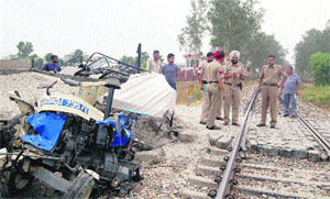 The badly crushed tractor-trailer at the unmanned level crossing in Kapurthala on Monday.