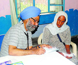 Chief cardiologist Dr GS Wander examines a patient during a medical camp.