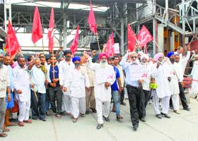 CPM members hold placards as they protest against PM Narendra Modi and the hike in rail fares at the railway station in Amritsar on Tuesday