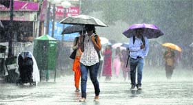 People walk through heavy rain in Shimla on Tuesday.