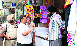 MC Commissioner Pradeep Sabharwal speaks to a shopkeeper during an anti-encroachment drive in Amritsar on Wednesday