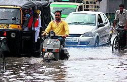 Commuters find their way through a water-logged road in Bathinda on Wednesday