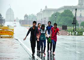Boys and girls enjoy rain in New Delhi on Wednesday. Several parts of the city receive rain today, bringing the temperatures down in the region as the monsoon season approaches