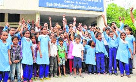 Students of Government Primary School, Radio Colony, protest outside the DC office in Jalandhar on Wednesday
