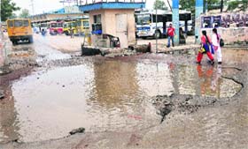Problematic: Commuters at the bus stand wade through water-filled craters to catch bus after early morning showers in Jalandhar on Wednesday