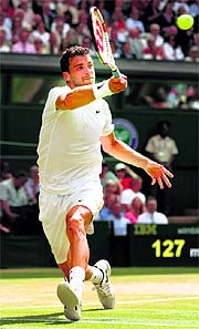 rigor Dimitrov returns to Andy Murray during their quarterfinal of the Wimbledon Championships in London on Wednesday