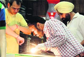 Fingerprint experts at the crime scene in a garment shop in Bathinda on Thursday.