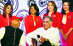 Ratan Tata, Chairman Emeritus of Tata Group, and Air Asia Group CEO Tony Fenandes with air hostesses during a press conference to celebrate the launch of Air Asia India in Bengaluru on Thursday
