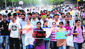 Research scholars take out a candle-light march in support of their demands from the PGI in Chandigarh on Thursday. 