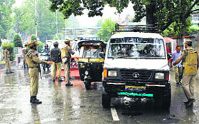 Policemen check vehicles amid rain in Srinagar on Thursday ahead of the Prime Ministers visit
