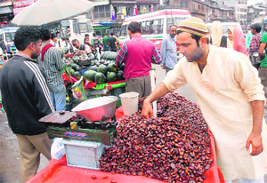A vendor sells dates on roadside during Ramadan in Srinagar on Thursday.