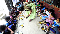 Students consume the mid-day meal at Government Primary School, Radio Colony, in Jalandhar on Thursday