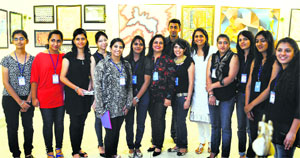 Artists pose for a photograph during an art exhibition in Ludhiana on Thursday.