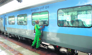 A railway worker cleans a coach before the trial run of a high-speed train between New Delhi and Agra in New Delhi on Thursday.