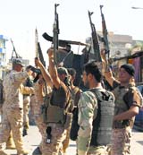 Securitymen gesture after clashes with followers of Mahmoud al-Sarkhi in Karbala.