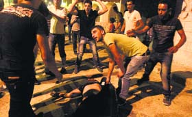 Palestinians aid a fellow protester hit by teargas during clashes with the Israeli military at Bethlehem on Wednesday.
